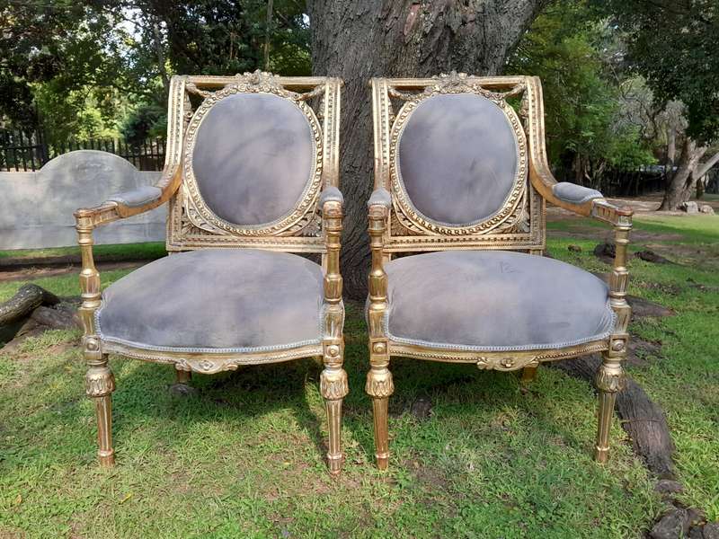 A Set of Eight French Style Ornately Carved and Gilded Dining Chairs (6 chairs and 2 Carvers)