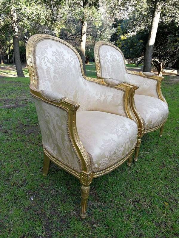 A Pair of French Louis XVI  Style Ornately Carved and Gilded Armchairs