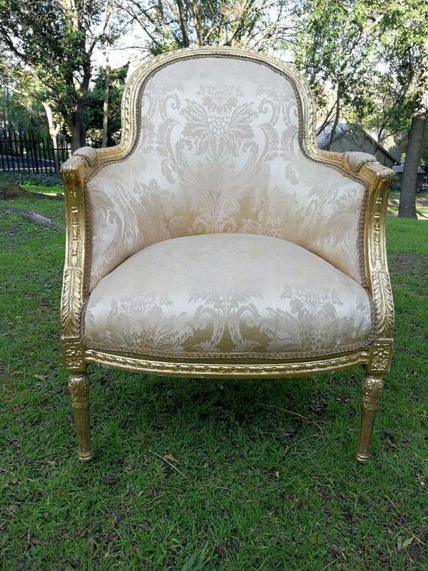 A Pair of French Louis XVI  Style Ornately Carved and Gilded Armchairs