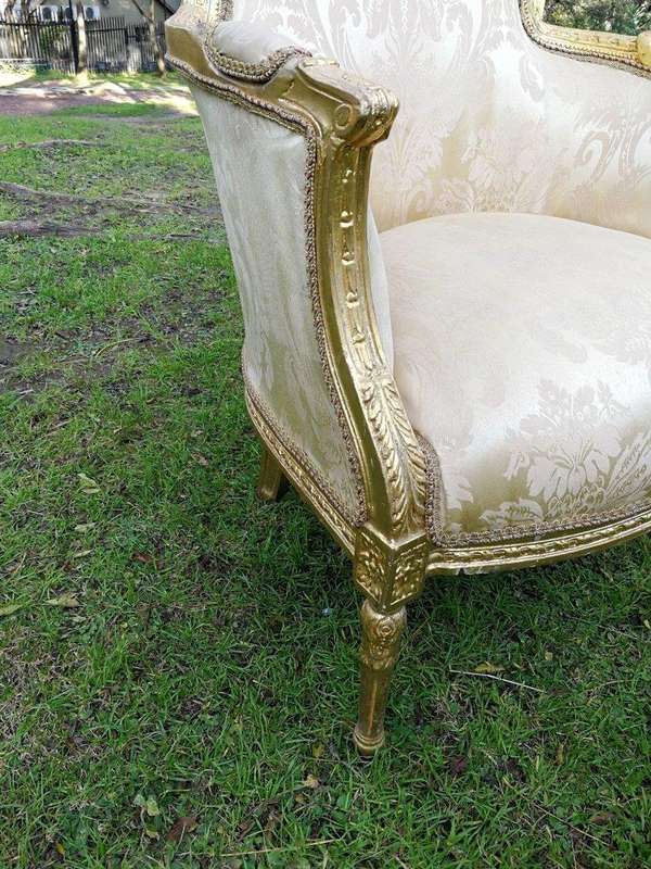 A Pair of French Louis XVI  Style Ornately Carved and Gilded Armchairs