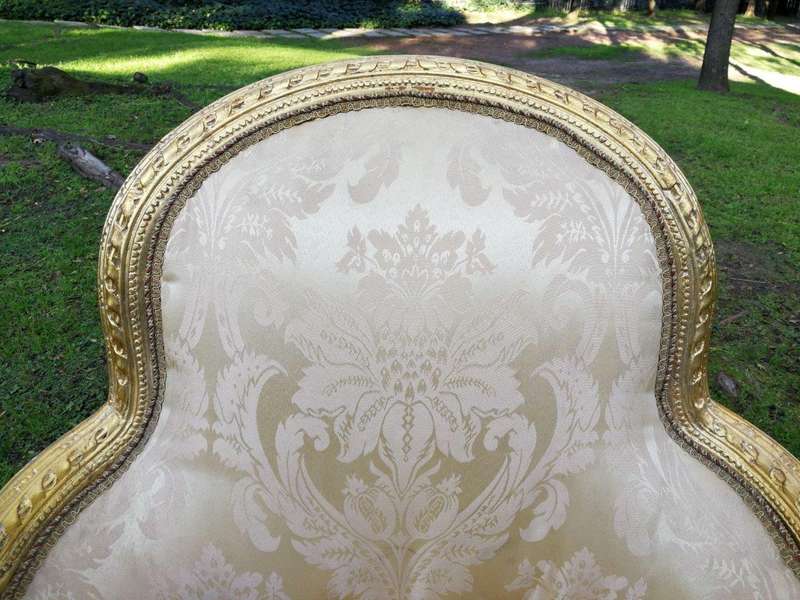 A Pair of French Louis XVI  Style Ornately Carved and Gilded Armchairs