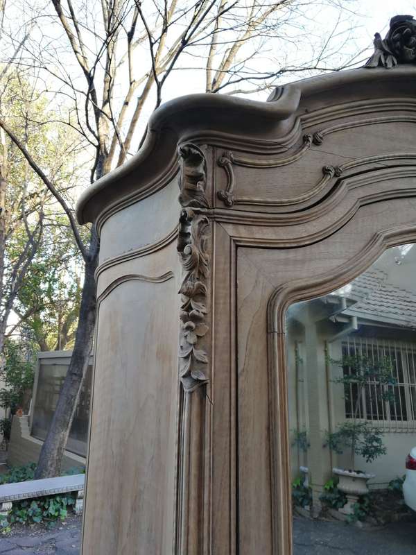 An Early 20th Century French-Style Carved Mahogany And Bevelled Mirrored Armoire in a Contemporar...