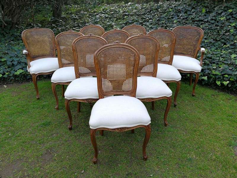 A 20th Century French Set Of Ten Walnut And Rattan Dining Chairs Consisting Of Two Carvers And Ei...