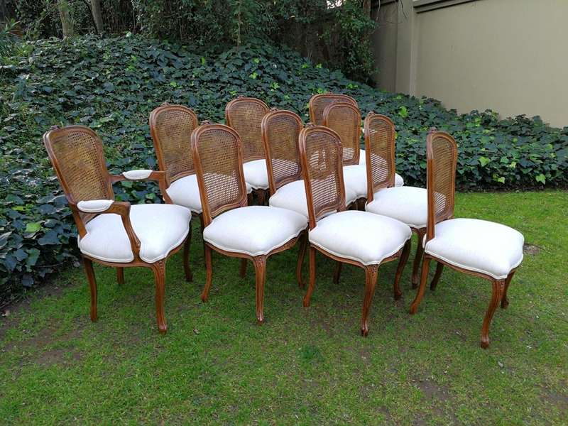 A 20th Century French Set Of Ten Walnut And Rattan Dining Chairs Consisting Of Two Carvers And Ei...