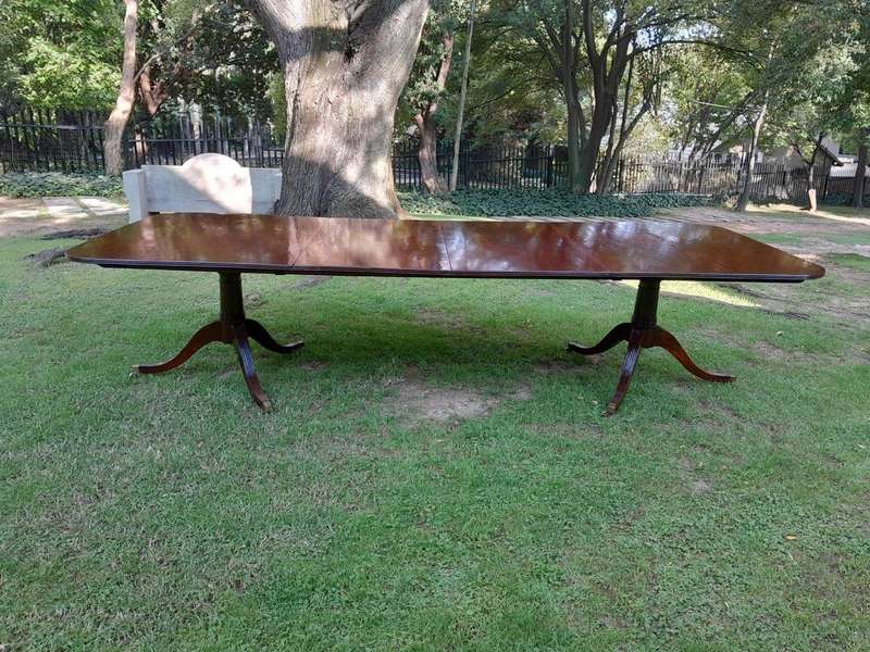 A 20th Century Regency-style Mahogany Extending Dining Table On Casters with Two Leaves and One O...