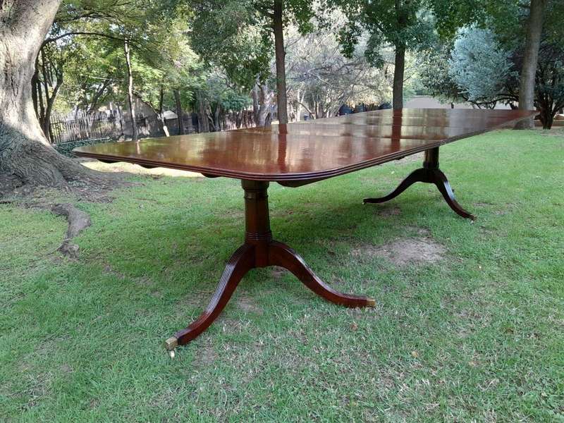 A 20th Century Regency-style Mahogany Extending Dining Table On Casters with Two Leaves and One O...