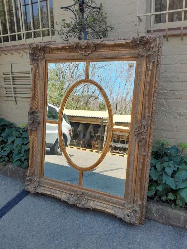 A Large and Heavily Carved Giltwood Bevelled Mirror