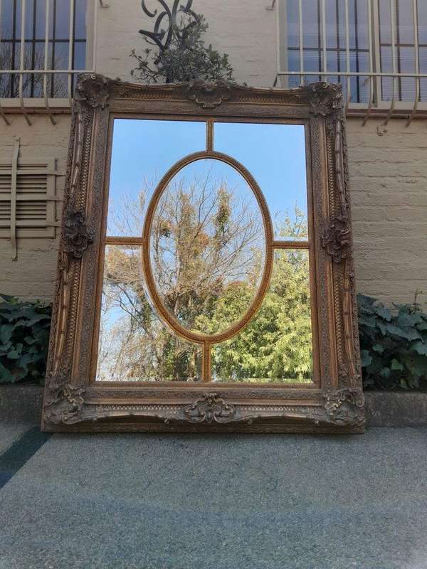 A Large and Heavily Carved Giltwood Bevelled Mirror