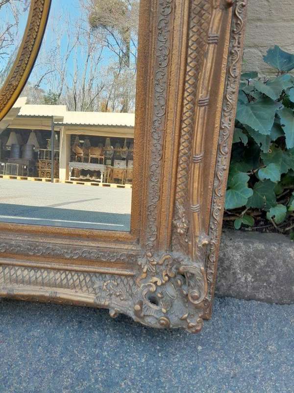 A Large and Heavily Carved Giltwood Bevelled Mirror