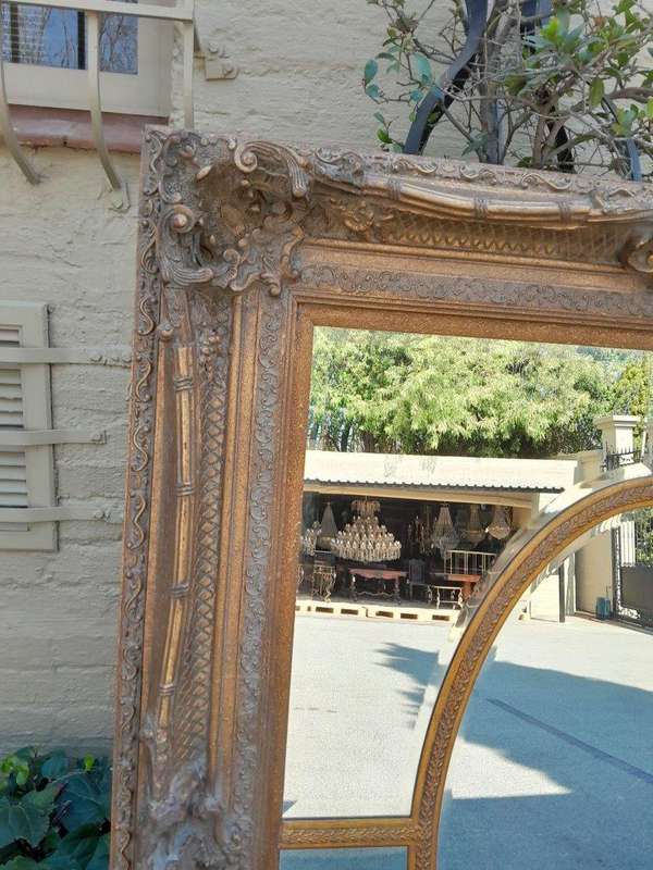 A Large and Heavily Carved Giltwood Bevelled Mirror