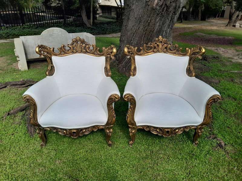 A French Style Pair of Ornately Carved Gilt Wood Armchairs