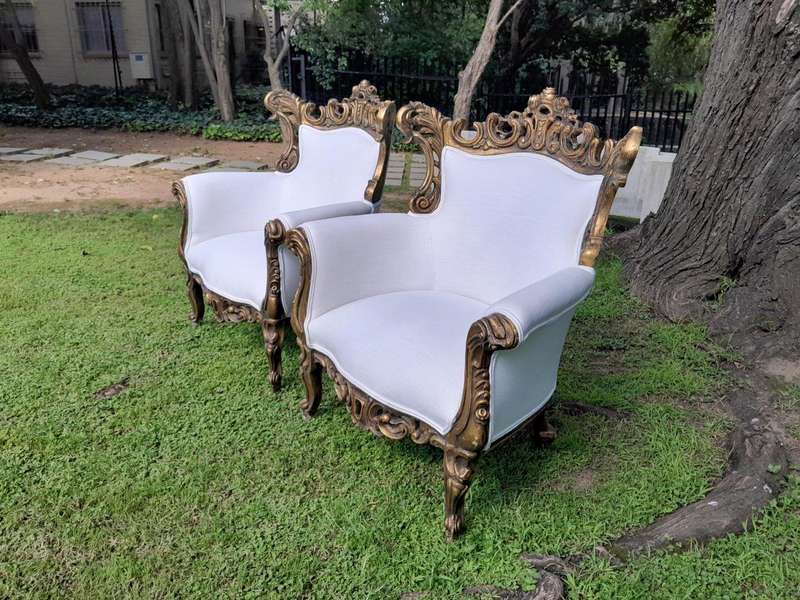 A French Style Pair of Ornately Carved Gilt Wood Armchairs