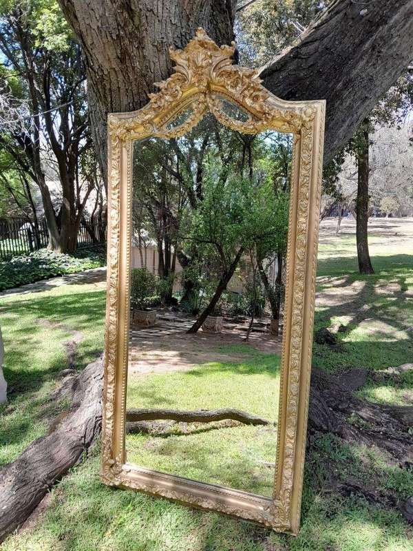 A French Rococo Style Ornately Carved and Gilded Bevelled Mirror