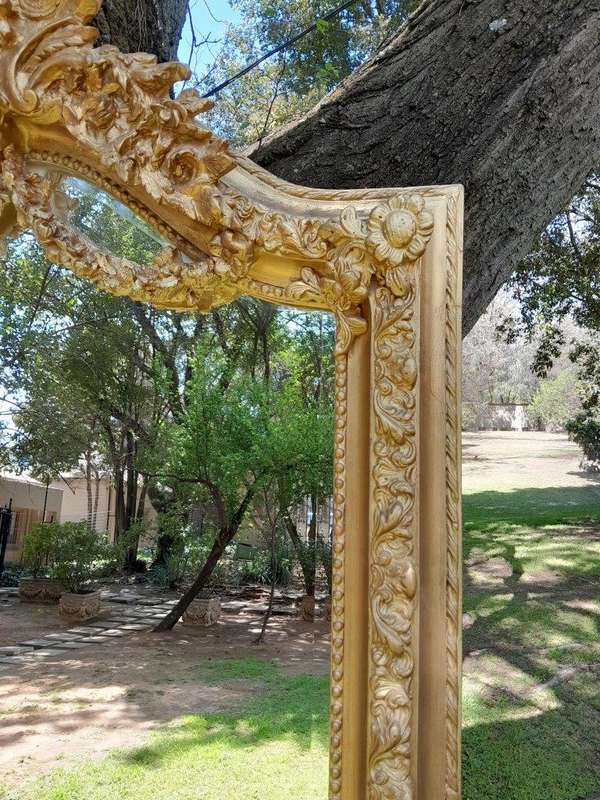 A French Rococo Style Ornately Carved and Gilded Bevelled Mirror