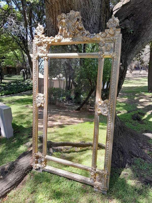 A French Rococo Style Ornately Carved and Gilded Bevelled Mirror