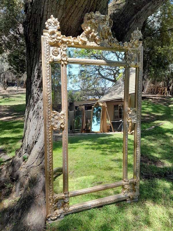 A French Rococo Style Ornately Carved and Gilded Bevelled Mirror