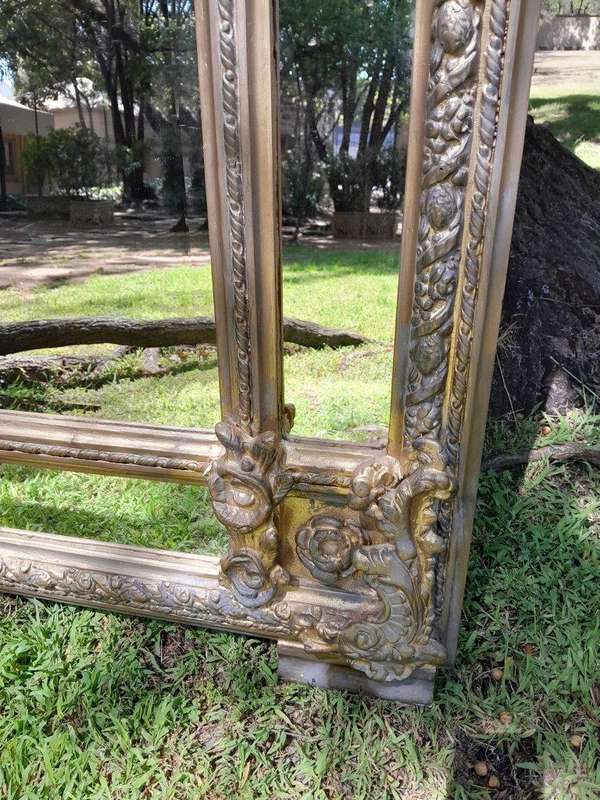 A French Rococo Style Ornately Carved and Gilded Bevelled Mirror