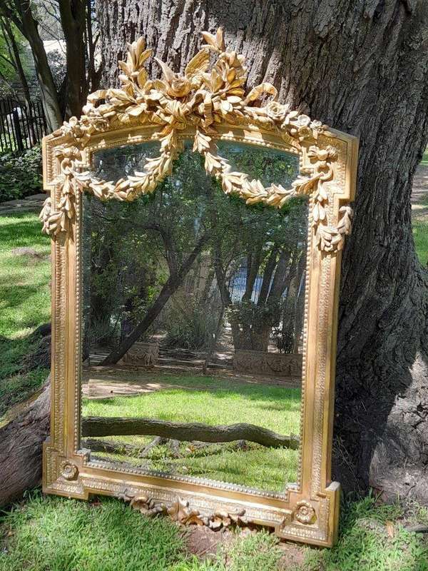 A French Rococo Style Ornately Carved and Gilded Bevelled Mirror