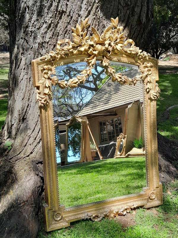 A French Rococo Style Ornately Carved and Gilded Bevelled Mirror