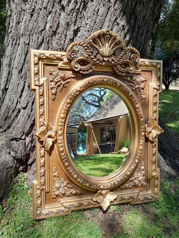 A 20th Century French Style Ornately Carved and Gilded Bevelled Mirror