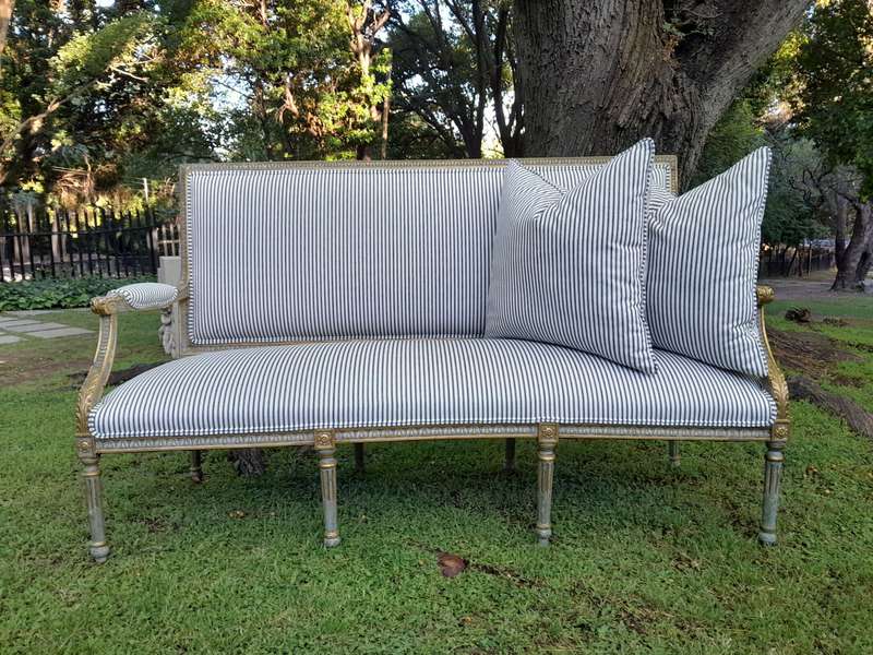 A 20th Century French  Style Carved and Hand Gilded Settee Upholstered in Ticking Fabric