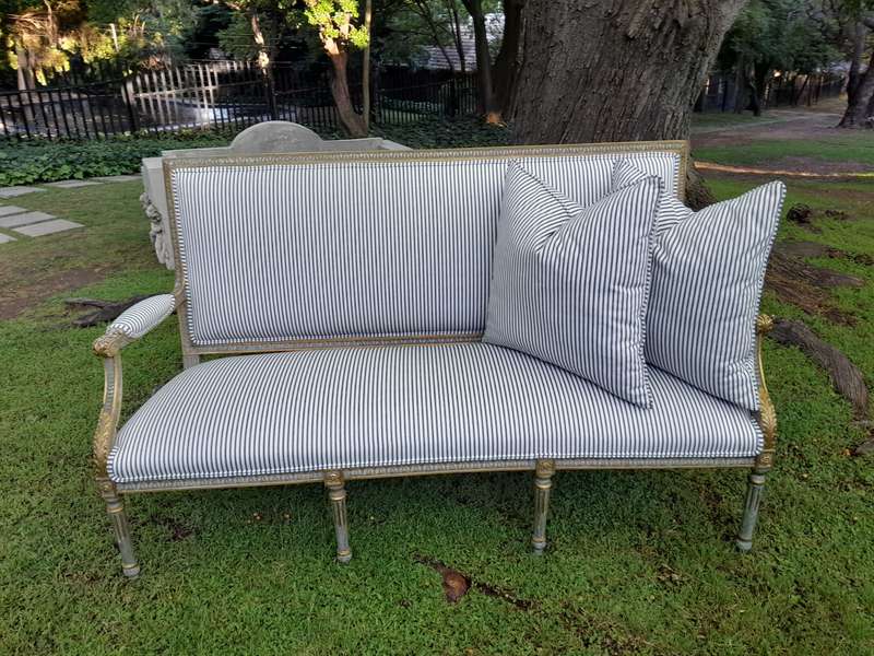 A 20th Century French  Style Carved and Hand Gilded Settee Upholstered in Ticking Fabric