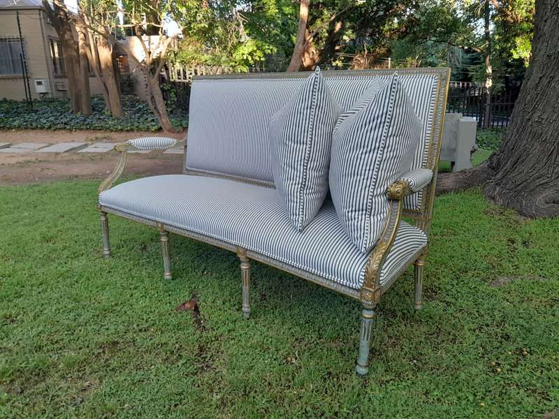 A 20th Century French  Style Carved and Hand Gilded Settee Upholstered in Ticking Fabric
