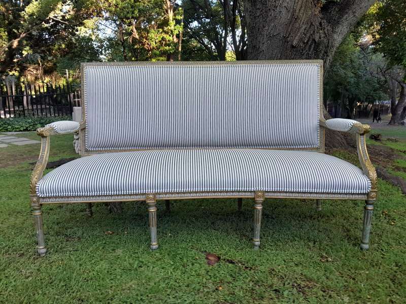 A 20th Century French  Style Carved and Hand Gilded Settee Upholstered in Ticking Fabric