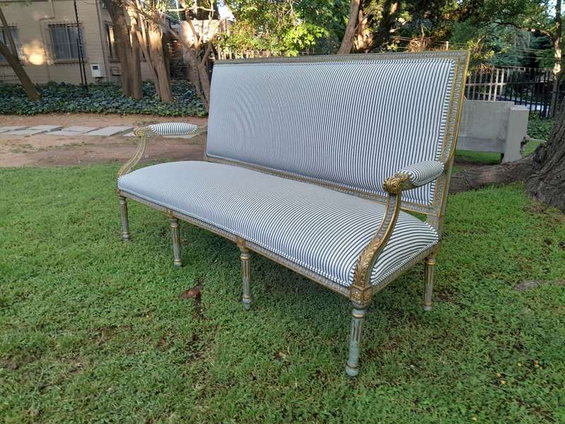 A 20th Century French  Style Carved and Hand Gilded Settee Upholstered in Ticking Fabric