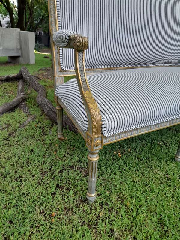 A 20th Century French  Style Carved and Hand Gilded Settee Upholstered in Ticking Fabric