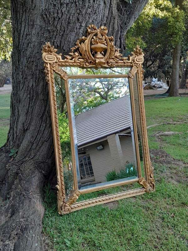 A French Rococo Style Ornately Carved and Gilded Bevelled Mirror