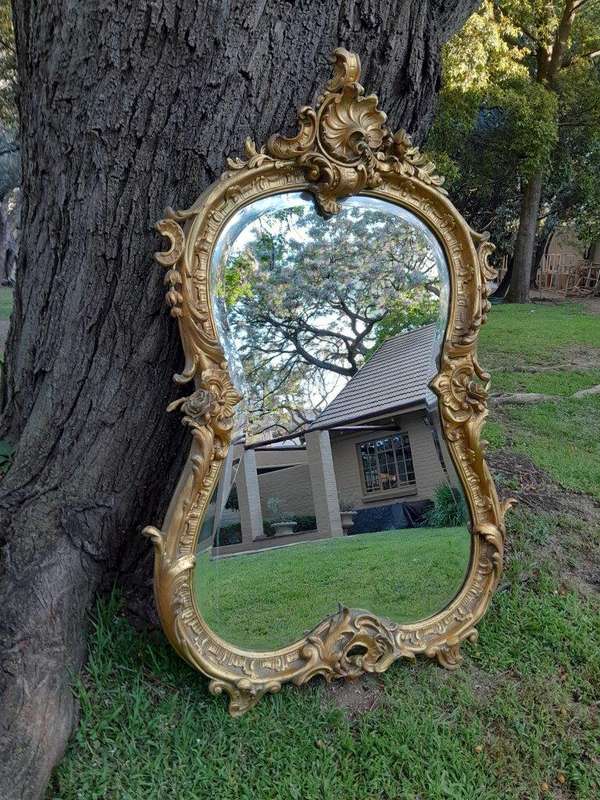 A French Rococo Style Ornately Carved and Gilded Bevelled Mirror