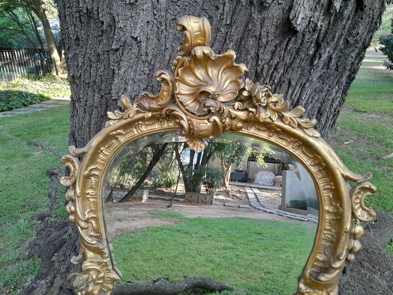A French Rococo Style Ornately Carved and Gilded Bevelled Mirror