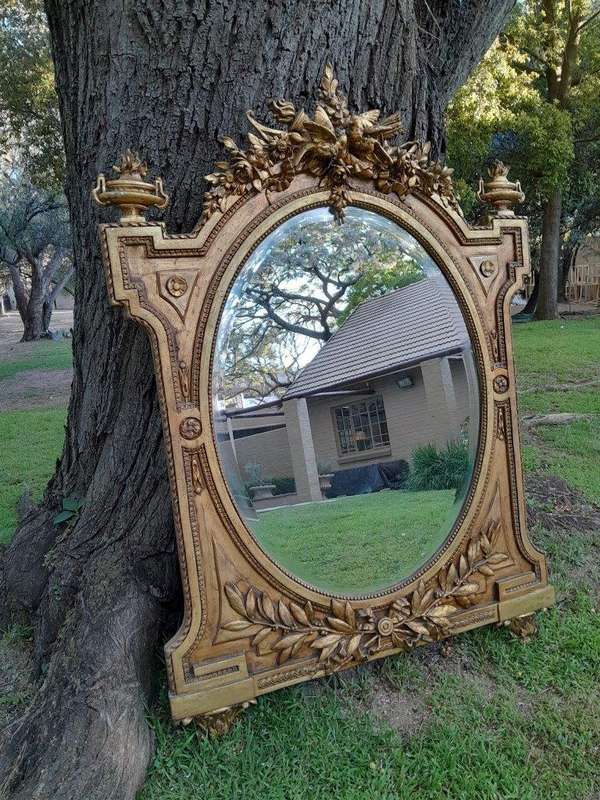 A French Rococo Style Ornately Carved and Gilded Bevelled Mirror