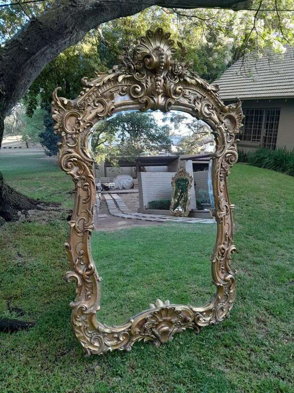 A French Rococo Style Ornately Carved and Gilded Bevelled Mirror