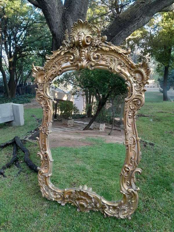 A French Rococo Style Ornately Carved and Gilded Bevelled Mirror