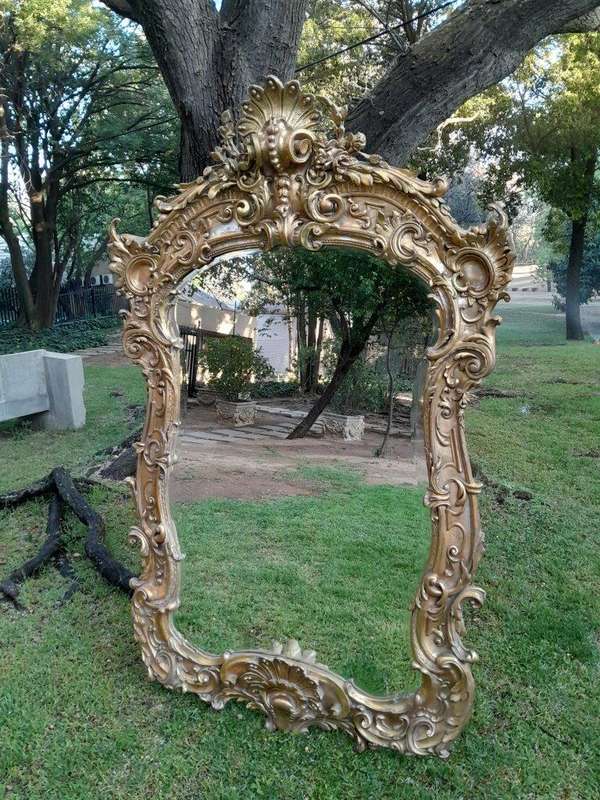A French Rococo Style Ornately Carved and Gilded Bevelled Mirror