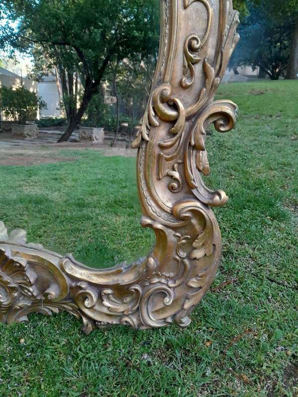 A French Rococo Style Ornately Carved and Gilded Bevelled Mirror