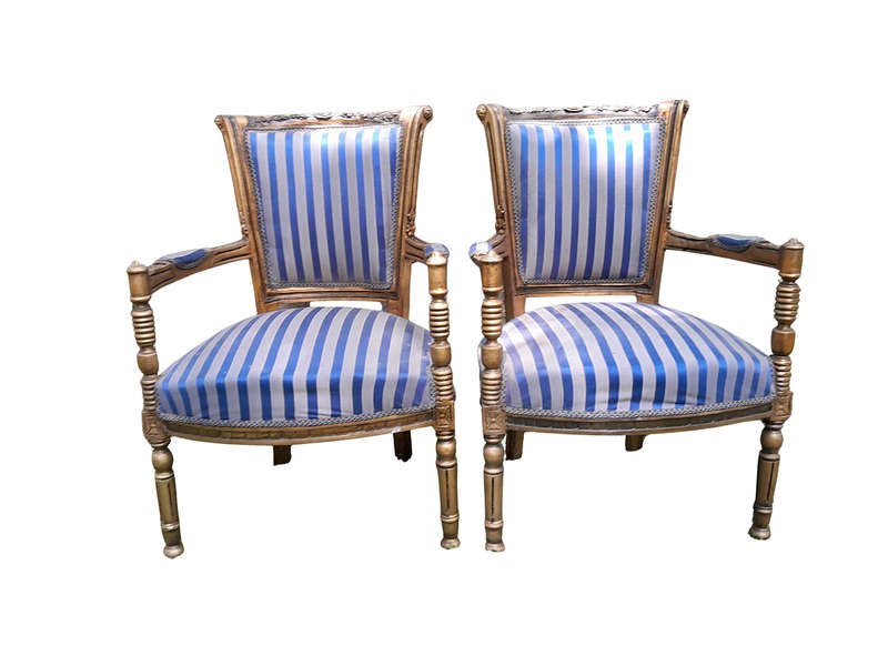 A Pair Of 20th Century French Louis XVI Styled Ornately Carved And Gilded Arm Chairs