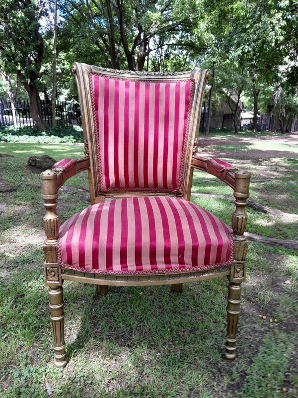 A Pair Of 20th Century French Louis XVI Styled Ornately Carved And Gilded Arm Chairs