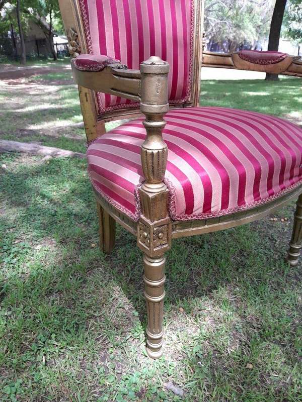 A Pair Of 20th Century French Louis XVI Styled Ornately Carved And Gilded Arm Chairs