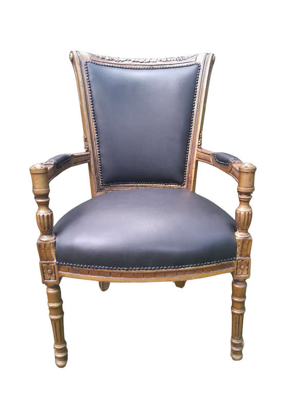 A 20th Century French Louis XVI Styled Ornately Carved And Gilded Arm Chair upholstered in black ...