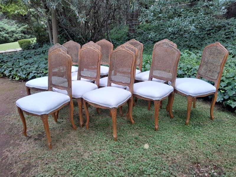 A Rare 20th Century Set Of Twelve French Colonial Style Walnut Rattan Dining Chairs
