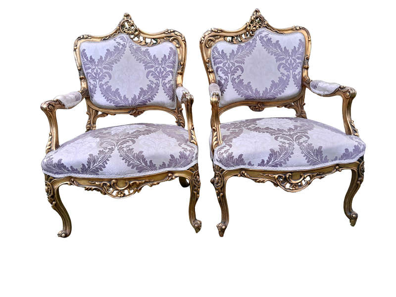 A 20th Century Pair Of French Rococo Style Ornately Carved Wooden Gilt-Wood Arm Chairs