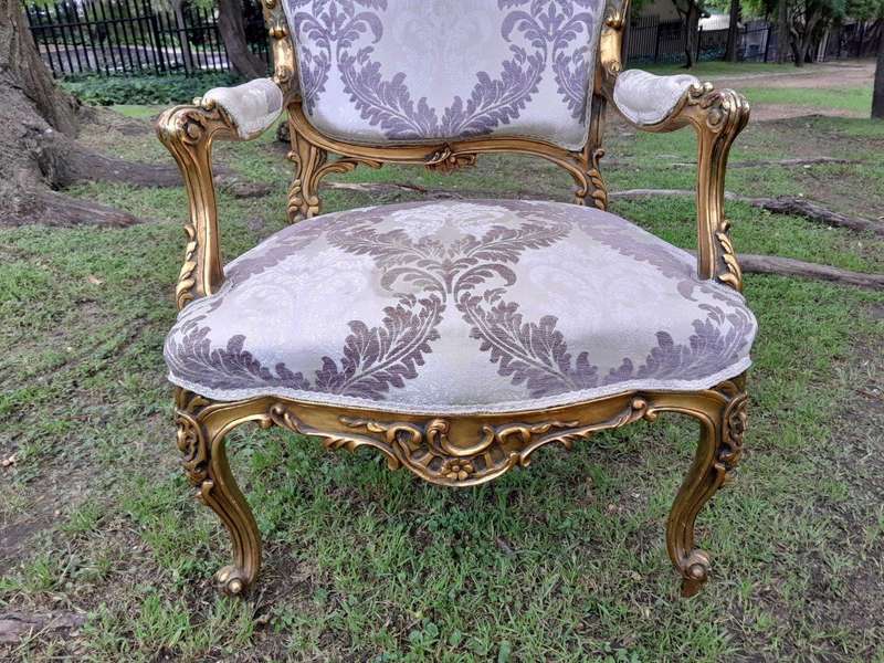A 20th Century Pair Of French Rococo Style Ornately Carved Wooden Gilt-Wood Arm Chairs
