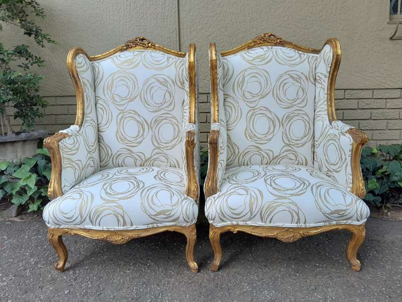 A French Style Pair of Hand Gilded Carved Wingback Chairs Upholstered in a Custom Made for The Cr...