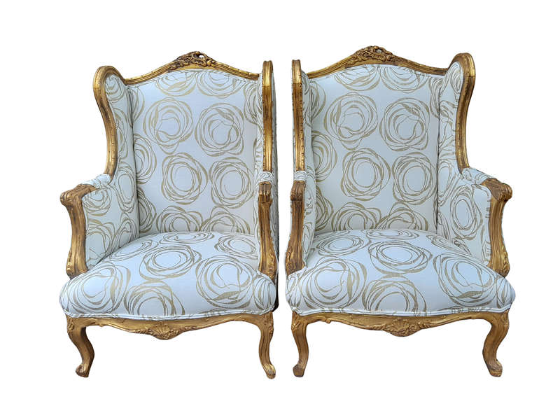 A French Style Pair of Hand Gilded Carved Wingback Chairs Upholstered in a Custom Made for The Cr...
