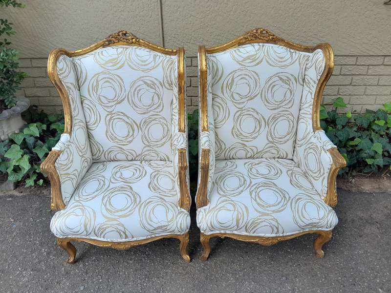 A French Style Pair of Hand Gilded Carved Wingback Chairs Upholstered in a Custom Made for The Cr...