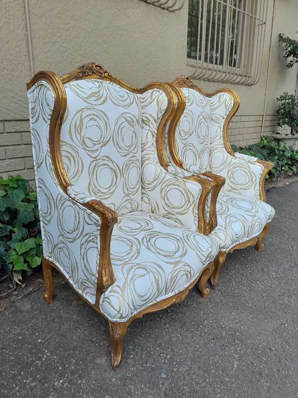 A French Style Pair of Hand Gilded Carved Wingback Chairs Upholstered in a Custom Made for The Cr...