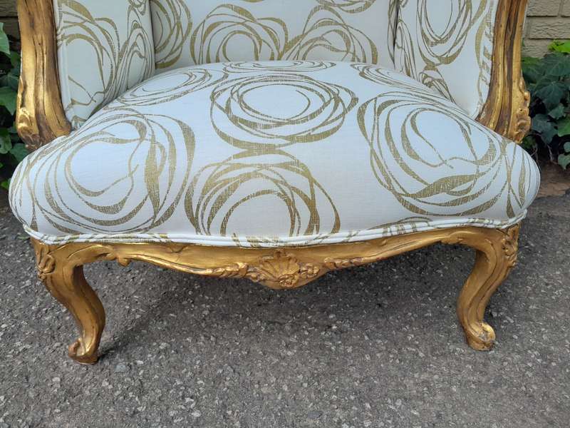 A French Style Pair of Hand Gilded Carved Wingback Chairs Upholstered in a Custom Made for The Cr...